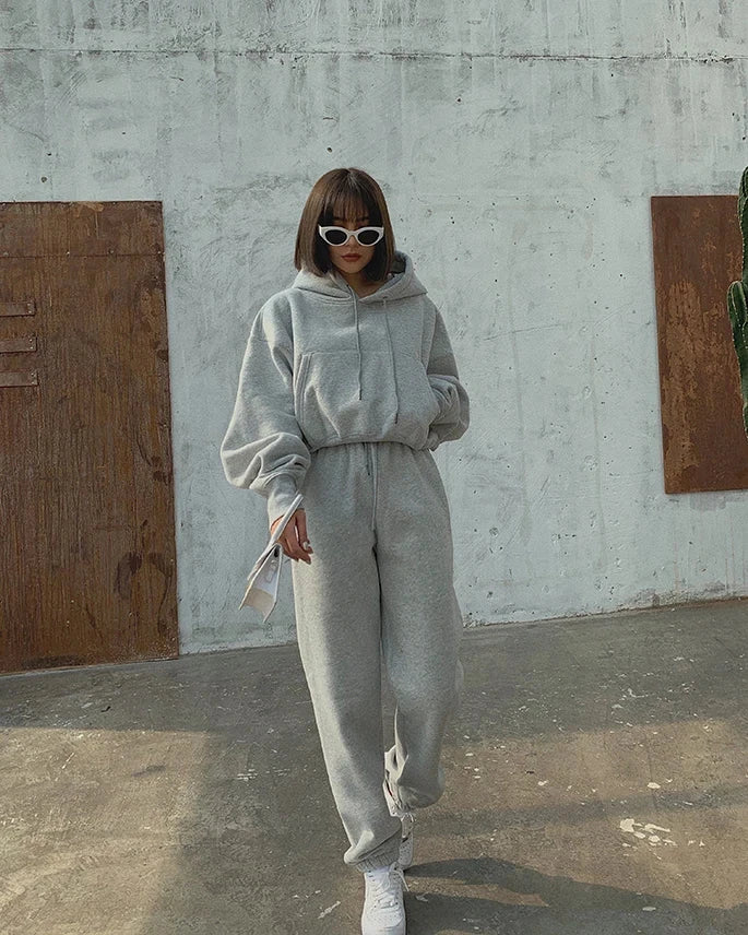 Women's casual tracksuit set featuring a hooded fleece pullover and ankle-length sweatpants in solid gray, ideal for autumn and winter.