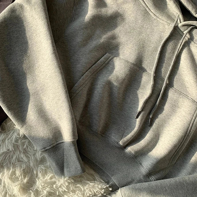 Women’s solid casual fleece tracksuit in gray, featuring a hooded pullover and sweatpants with pockets. Ideal for winter and spring sportswear.