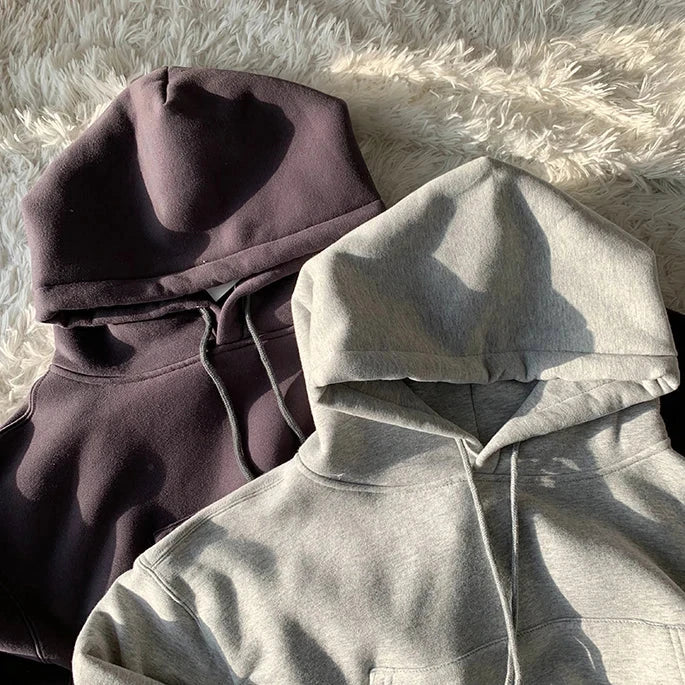 Women's casual fleece hoodies, solid color, hooded style, displayed on a soft surface in gray and dark gray shades.