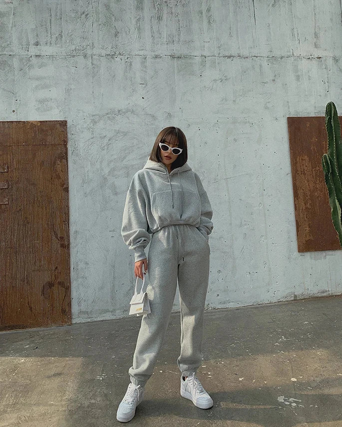 Women's casual tracksuit in solid color, featuring a hooded pullover sweatshirt and fleece sweatpants.