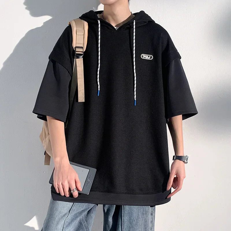 Oversized black waffle hooded short sleeve t-shirt in Y2K streetwear style with graphic print, ideal for casual urban outfits.