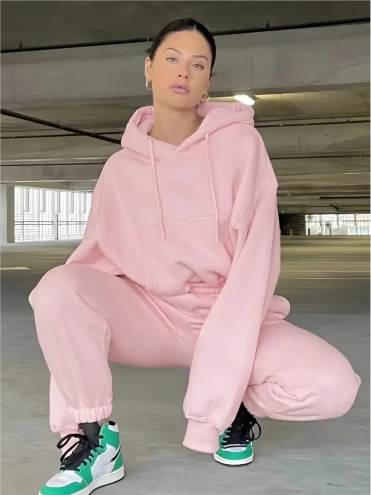 Women's fleece hoodie and sweatpants set in solid pink, featuring a casual, comfortable style ideal for winter and spring.