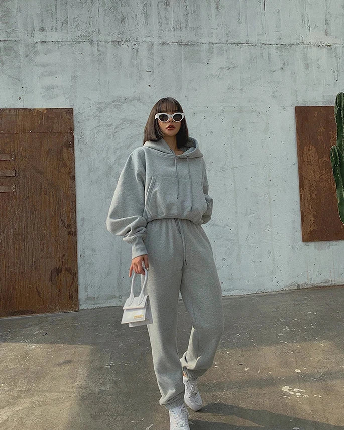 Women's casual grey hooded tracksuit set with fleece sweatpants and pullover, ideal for winter and spring sports activities.