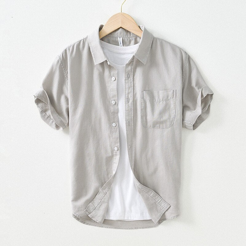 Men's solid color casual short-sleeved cotton linen shirt on hanger.