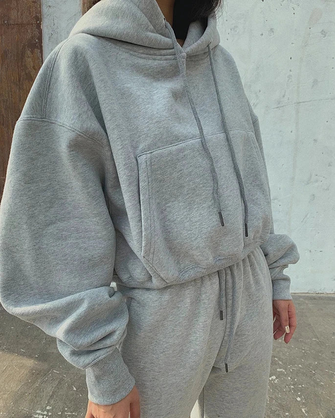 Women's grey fleece hoodie and sweatpants set, featuring a casual solid design with batwing sleeves, hood, and pockets. Perfect for autumn and winter sports or lounging.