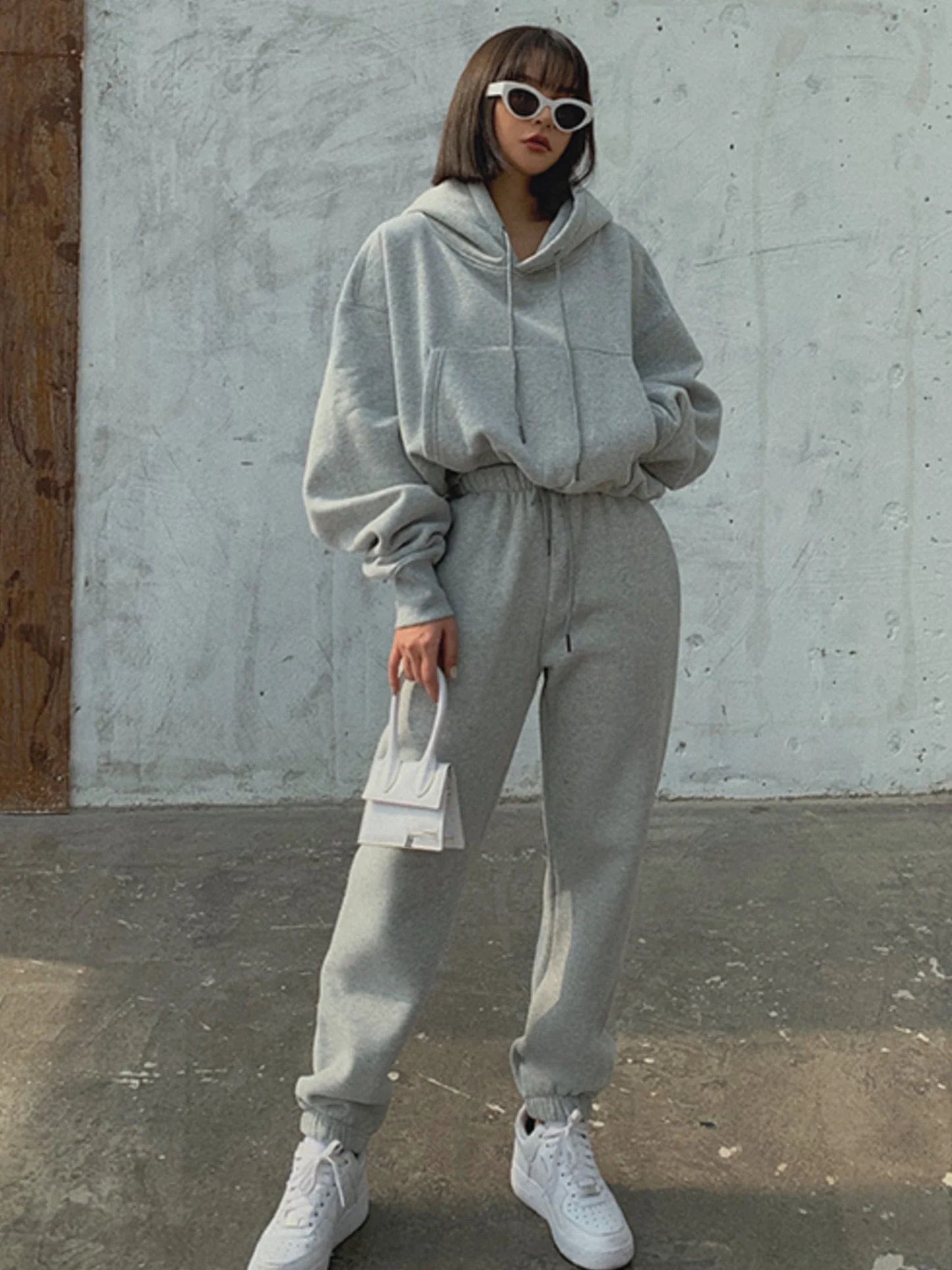 Women's casual gray fleece tracksuit set with hooded sweatshirt and sweatpants.