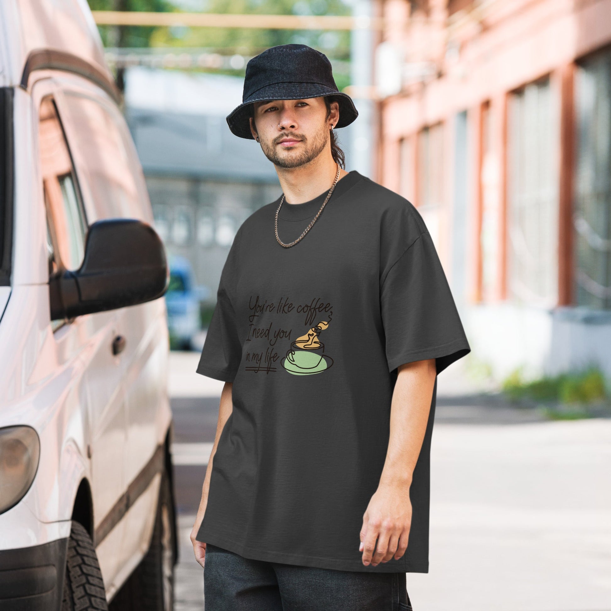 Man wearing an oversized faded t-shirt T130524 by a van, showcasing a casual street style.