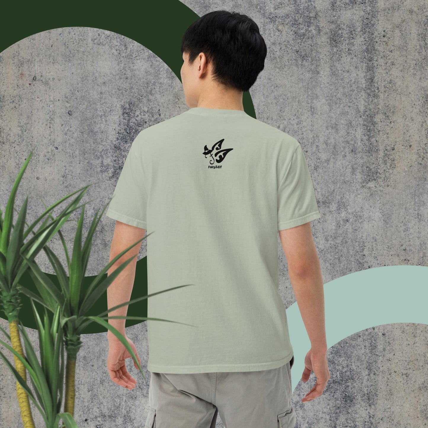 Man wearing Switch Man garment-dyed heavyweight t-shirt, sage green, relaxed fit, outdoor setting.